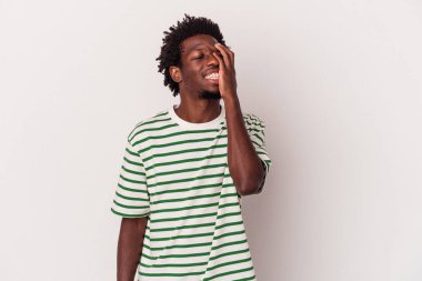 Genç Afro-Amerikan erkeği beyaz arka planda izole edilmiş mutlu, kaygısız, doğal duygulara gülüyor..