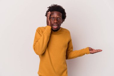 Beyaz arka planda izole edilmiş genç Afro-Amerikalı adam, avuç içi fotokopi alanı tutmaktan etkilenmiş..