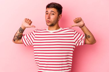 Sarı arka planda izole edilmiş dövmeleri olan beyaz bir genç gururlu ve kendinden emin..