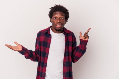 Genç Afrikalı Amerikalı bir adam beyaz arka planda izole edilmiş ve elinde bir ürün tutuyor..