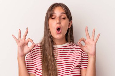 Beyaz arka planda izole edilmiş genç beyaz kadın sıkı çalışma gününden sonra rahatlıyor, yoga yapıyor..