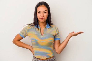 Beyaz arka planda izole edilmiş genç Latin bir kadın bir avuç içinde fotokopi alanı ve belinde bir el daha olduğunu gösteriyor..