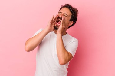 Pembe arka planda izole edilmiş beyaz bir adam heyecanlı bir şekilde bağırıyor..