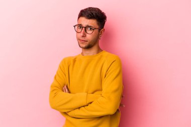 Sarı arka planda izole edilmiş dövmeleri olan beyaz bir genç şüpheli, belirsiz, seni muayene ediyor..