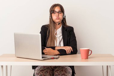 Beyaz arka planda tek başına seyahat eden beyaz tenli genç bir kadın yanakları patlatıyor, yorgun bir ifade takınıyor. Yüz ifadesi kavramı.