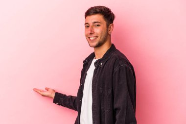 Sarı arka planda dövmeleri olan beyaz bir genç hoş bir yüz ifadesi sergiliyor..