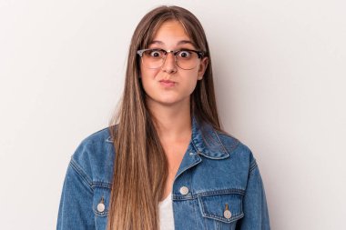 Beyaz arka planda izole genç beyaz kadın yanakları üflüyor, yorgun bir ifadesi var. Yüz ifadesi kavramı.