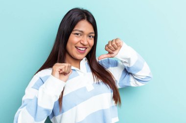 Mavi arka planda izole edilmiş genç Venezuelalı kadın gururlu ve kendinden emin hissediyor, örnek olarak..