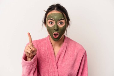 Young caucasian woman wearing a facial mask isolated on white background having an idea, inspiration concept.