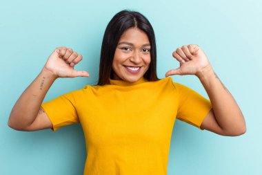 Mavi arka planda izole edilmiş genç Venezuelalı kadın gururlu ve kendinden emin hissediyor, örnek olarak..