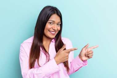 Genç Venezuelalı bir kadın mavi arka planda izole edilmiş..