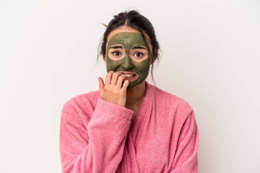 Young caucasian woman wearing a facial mask isolated on white background biting fingernails, nervous and very anxious.