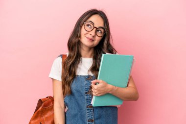 Young caucasian student woman isolated on pink background dreaming of achieving goals and purposes