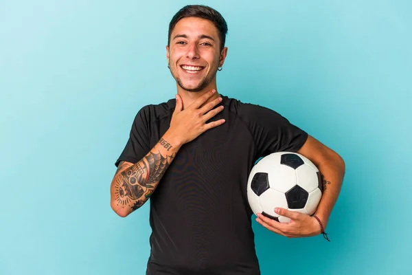 Young Man Playing Soccer Holding Ball Isolated Blue Background Laughs — Photo