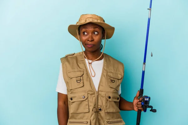 Young African American Fisherwoman Holding Rod Isolated Blue Background Confused — Stock Photo, Image