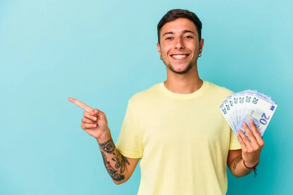 Joven Hombre Caucásico Sosteniendo Billetes Aislados Sobre Fondo Azul Sonriendo — Foto de Stock