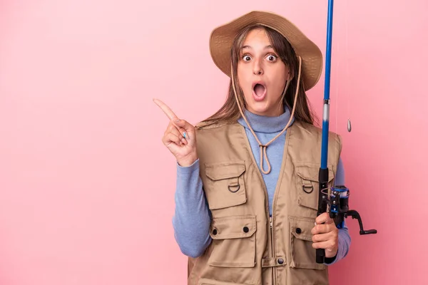 Young Caucasian Fisherwoman Holding Rod Isolated Pink Background Pointing Side — Stock Photo, Image