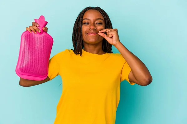 Young African American Woman Holding Hot Bag Water Isolated Blue — Stockfoto