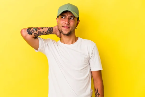 Young Caucasian Man Tattoos Isolated Yellow Background Touching Back Head — стоковое фото