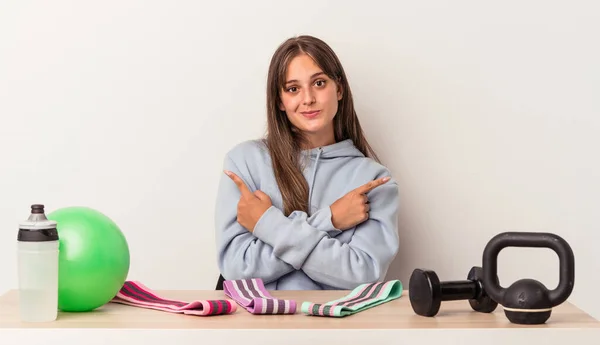 Junge Kaukasische Frau Sitzt Einem Tisch Mit Sportgeräten Isoliert Auf — Stockfoto