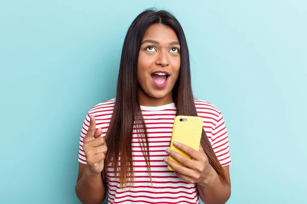 Junge Venezolanerin Hält Handy Isoliert Auf Blauem Hintergrund Und Zeigt — Stockfoto