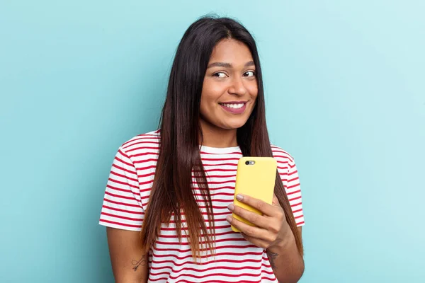 Молода Венесуелька Тримає Мобільний Телефон Ізольований Синьому Фоні Дивиться Посмішку — стокове фото