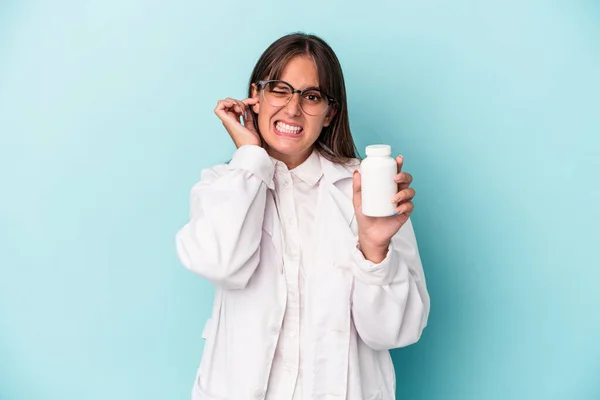 Junge Apothekerin Hält Tabletten Isoliert Auf Blauem Hintergrund Und Bedeckt — Stockfoto