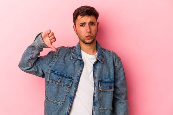 Sarı arka planda dövmeleri olan, hoşlanmadığı bir hareket gösteren beyaz, genç bir adam. Anlaşmazlık konsepti.