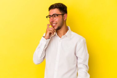 Sarı arka planda izole edilmiş beyaz dövmeli genç bir adam. Bir şeyin fotokopi odasına baktığını düşünerek rahatlamış..