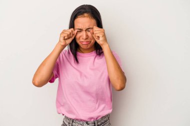 Beyaz arka planda yalnız kalmış, ağlayan ve sızlanan genç Latin bir kadın..