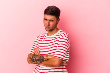 Sarı arka planda izole edilmiş dövmeleri olan genç beyaz bir adam tekrarlanan bir görevden yoruldu..