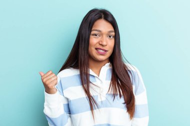 Genç Venezuelalı bir kadın mavi arka planda izole edilmiş..