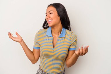 Beyaz arka planda izole edilmiş genç Latin bir kadın neşeli bir şekilde gülüyor. Mutluluk kavramı.