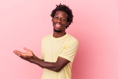 Pembe arka planda izole edilmiş genç Afro-Amerikalı bir adam. Elinde bir fotokopi odası var..