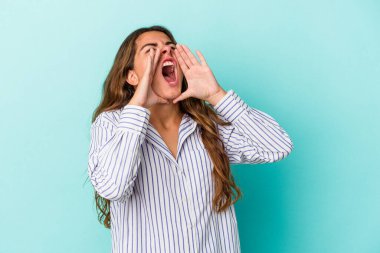 Mavi arka planda izole edilmiş beyaz bir kadın heyecanlı bir şekilde bağırıyor..
