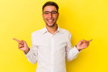 Sarı arka planda, farklı kopya alanlarını gösteren dövmeleri olan genç beyaz bir adam. Birini seçiyor, parmaklarıyla gösteriyor..