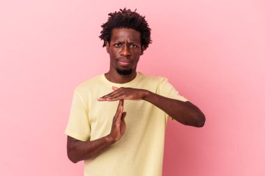 Pembe arka planda izole edilmiş genç Afro-Amerikan bir jest yapıyor..