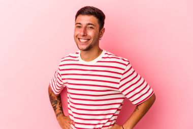 Sarı arka planda izole edilmiş, mutlu, gülümseyen ve neşeli dövmeleri olan beyaz bir genç..