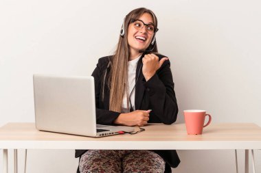 Beyaz arka plan noktalarında yalnız başına seyahat eden beyaz tenli genç bir kadın. Baş parmak uzakta, gülüyor ve kaygısız..