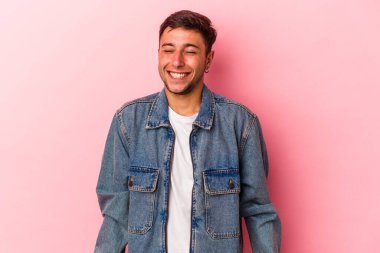 Sarı arka planda izole edilmiş dövmeleri olan genç beyaz adam gülüyor ve gözlerini kapıyor, rahatlamış ve mutlu hissediyor..