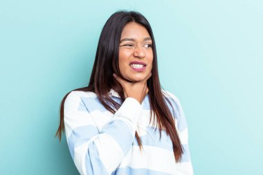 Genç Venezuelalı kadın mavi arka planda izole edilmiş kafasının arkasına dokunuyor, düşünüyor ve bir seçim yapıyor..