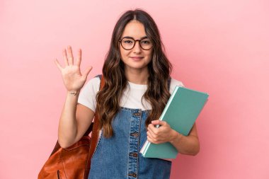 Young caucasian student woman isolated on pink background smiling cheerful showing number five with fingers.