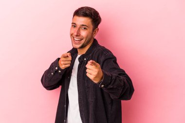 Sarı arka planda izole edilmiş dövmeli beyaz bir adam. Önü işaret eden neşeli gülümsemeler..