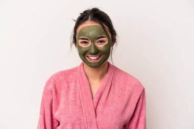 Young caucasian woman wearing a facial mask isolated on white background happy, smiling and cheerful.