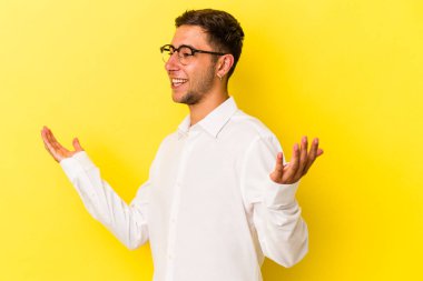 Sarı arka planda izole edilmiş dövmeleri olan, neşeli gülüşlü beyaz bir genç. Mutluluk kavramı.