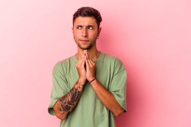 Sarı arka planda dövmeleri olan genç beyaz bir adam. Kafasında bir plan kuruyor..