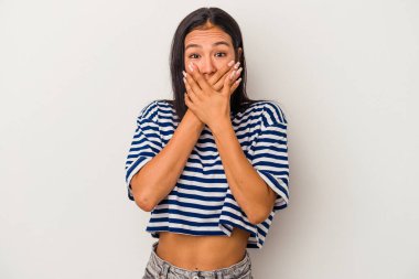 Beyaz arka planda izole edilmiş genç Latin bir kadın. Ağzı kapalı ve elleri endişeli görünüyor..