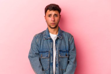 Sarı arka planda izole edilmiş beyaz dövmeli genç bir adam üzgün, ciddi yüzlü, mutsuz ve hoşnutsuz..