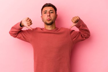 Sarı arka planda dövmeleri olan, hoşlanmadığı bir hareket gösteren beyaz, genç bir adam. Anlaşmazlık konsepti.