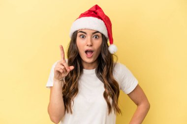 Kafkasyalı genç bir kadın, sarı arka planda izole edilmiş bir şekilde Noel 'i kutluyor. Bir fikri var, ilham verici bir kavram..